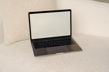 Opened laptop with blank screen on couch in room