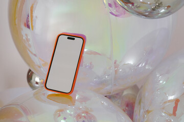 Smartphone with blank screen placed on glassy decorative ball