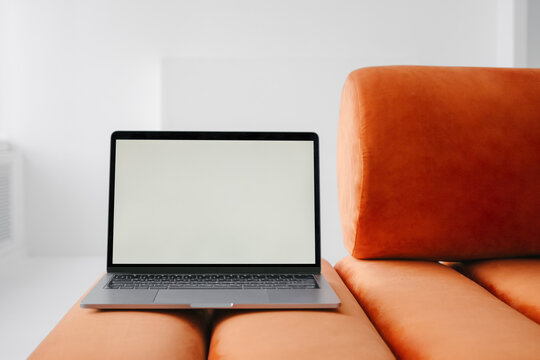Laptop placed on armless sofa at home