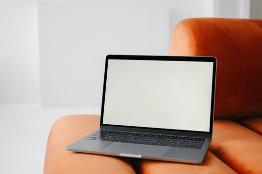 Laptop placed on armless sofa at home