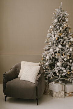 Interior of room with Christmas tree and armchair with pillow