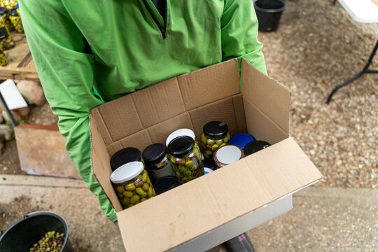 man carries box with canned food