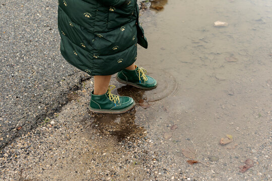 girl stepping in a puddle of water