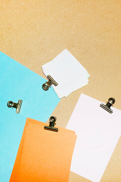 Colourful papers and post-it with golden clips in a work office