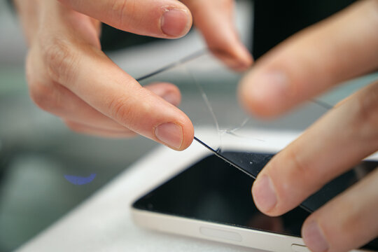 Man removing a mobile broken screen protector