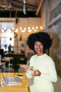 Cheerful woman eating at office