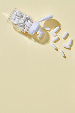 Still life with white pills and glass bottle