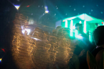 Water effect reflecting neon lights and people having fun at nightclub