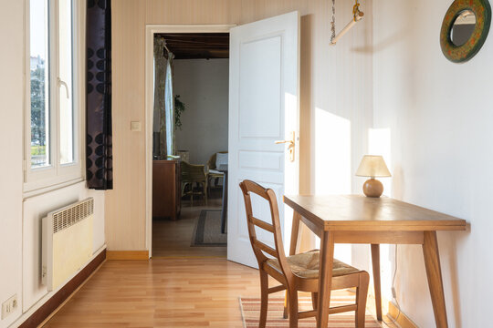 Vintage study room with wooden furniture, open window and sunlight