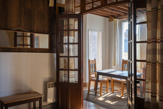 Living room table touched by sunlight seen through wood and glass door