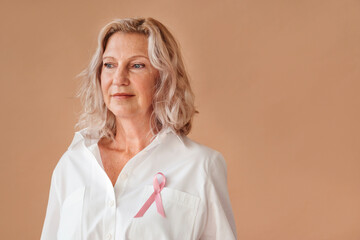 Confident senior woman with pink ribbon.