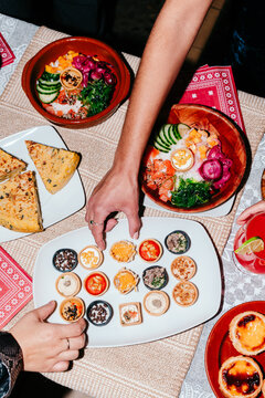 Hands reaching for food at dinner table