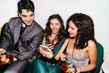 Friends looking at phone at a party