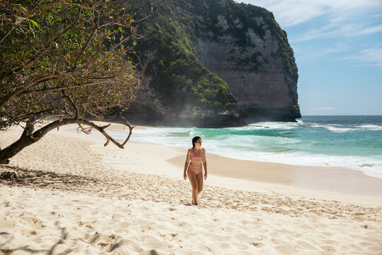 woman walking on the sand of a paradisiacal beach