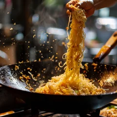 Fotobehang Skillful hands tossing noodles in a wok Pad Thai © WARIT_S