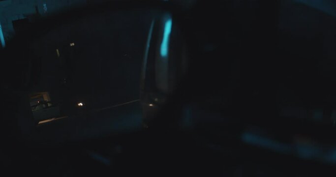Police Car Spots vehicle, Officer Pulls Over Vehicle at Night in the Rain with Flashing Lights. Side View Mirror Point Of View, Heavy Rain. Shines Flashlight at vehicle.