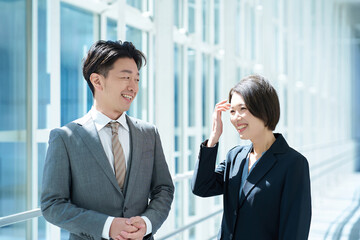 会話するスーツ姿の男女