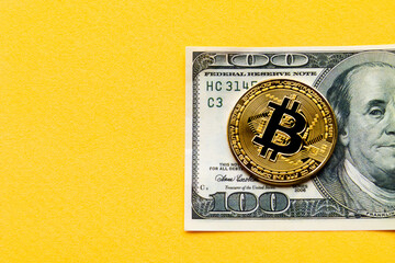 a bitcoin cryptocurrency on a hundred dollar bill placed on the right side of the image on a yellow background and space for text, concept of web3 exchange and blockchain