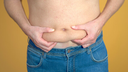 Naklejka premium Man assessing his belly fat problem