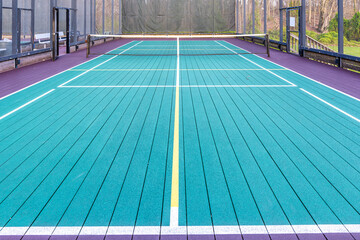 Elevated Platform Tennis, Paddle Ball courts with yellow pickelball lines, net and chicken wire...