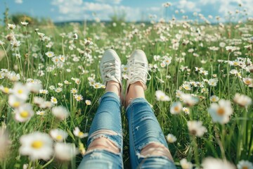 Legs of  girl lying on the spring blooming meadow and flower.