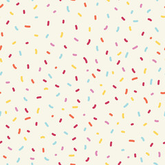 Seamless sprinkle pattern. Colorful background design with cute pastel colored sprinkles. 
