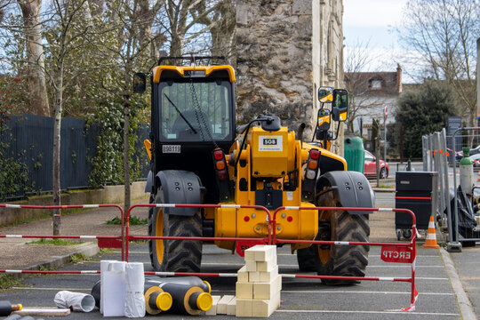 France, 10 March 2024: Construction Equipment and Safety Barriers on Urban Street.