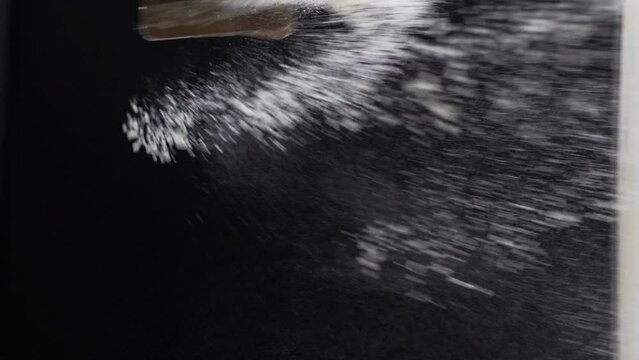 Tossing the flour in the air by his hands during the cooking