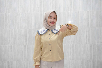 Expression of Asian Indonesian woman wearing hijab and yellow shirt