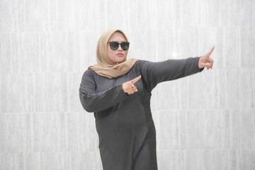 Expression of an Asian Indonesian woman wearing a brown hijab and black clothes