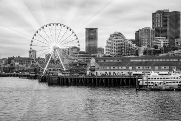 2023-12-31 THE SEATTLE WATER FRONT WITH OFFICE TOWERS THE GREAT WHEEL NEXT TO PIER 54 ON ELLIOTT BAY- - obrazy, fototapety, plakaty