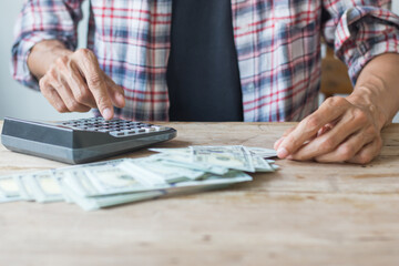 Businessman uses a calculator to calculate money,saving concept,soft focus.