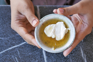 butter cream and honey in a bowl on table .