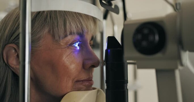 Patient, slit lamp or ophthalmology as eye test, medicine or optometry as healthcare technology. Mature woman, eyeball or light in glaucoma, exam or consultation to diagnose lens, cornea or myopia