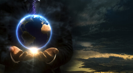 地球を模した球体を手中に収めるスーツ姿の男性の手と光　都市伝説・掌握・陰謀・操作・世界のイメージ