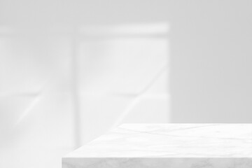 Marble table with white stucco wall texture background with light beam and shadow, suitable for product presentation backdrop, display, and mock up.
