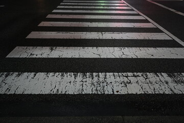 信号の光が反射する夜の横断歩道