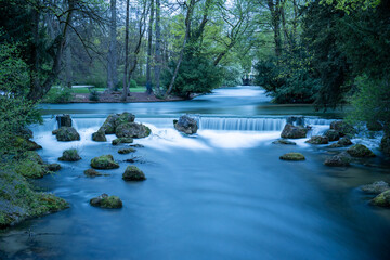 Small, artificial waterfall in the Eisbach, English Garden, Munich, Bavaria, Germany at blue hour