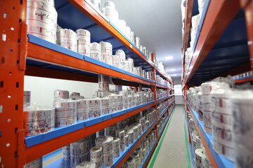 primary packaging material filled warehouse inside epoxy floor for pharmaceutical chemical production factory. packing materials plastic aluminum wrapping kept on pellet shelves in a storage room area