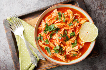 Traditional mexican crockpot chicken tomato salsa close-up in a bowl on a wooden board. Horizontal top view from above