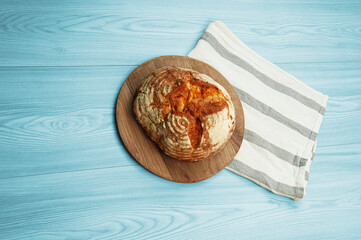 baked Italian bread on a light wooden table. ciabatta on a white towel on a wooden background	