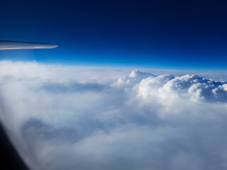 Airbus A340 flight in the blue sky and through the clouds, view from the plane window