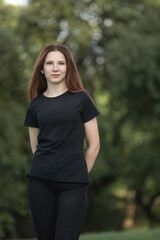 Portrait of a young beautiful long-haired girl outdoors in dark clothes.