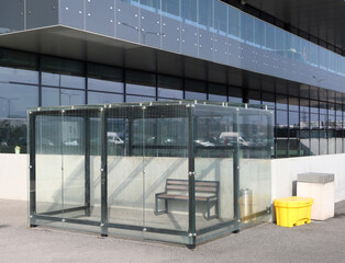 The smoking area near the store is fenced with glass sheets