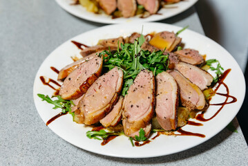 Herb-Crusted Pork Tenderloin Slices on Plate. Sliced herb-crusted pork tenderloin arranged on a...