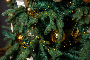 Decorated Christmas Tree Close-Up. Close-up view of a Christmas tree adorned with golden baubles,...