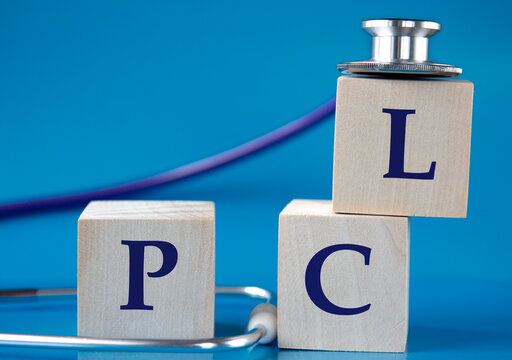 PCL - acronym on wooden large cubes on blue background with stethoscope