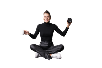 A young woman in business casual attire levitating with a coffee mug in one hand and a clock in the other, isolated on a white background, depicting time management