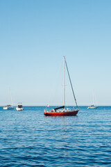 Fototapeta premium Voilier sur la mer méditerranée. Bateau à la coque rouge. Bateaux de plaisance à la mer.