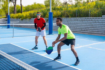 Obraz premium Multiracial team of pickleball players in an outdoor court